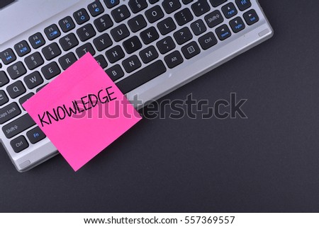 Sticky note on keyboard with text KNOWLEDGE