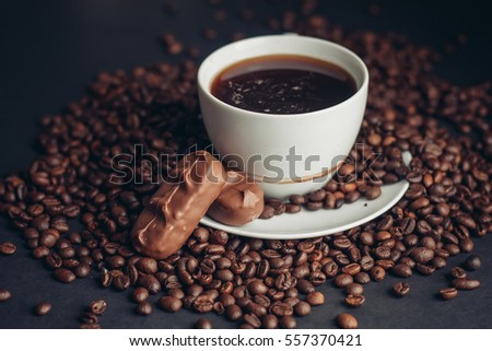 coffee beans, black background, cup, saucer  with chocolate