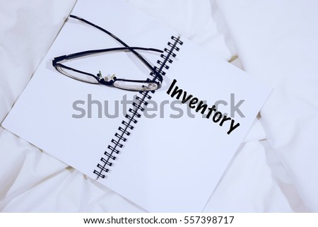 Wording INVENTORY on notebook with spectacle at bed. Stock Checking Retail Concept