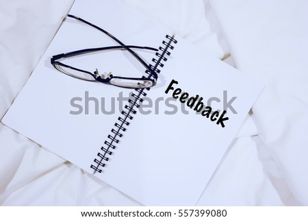 Wording FEEDBACK on notebook with spectacle at bed. Customer service relatinship Concept