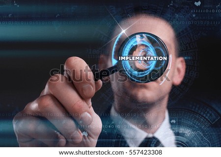 Business, Technology, Internet and network concept. Young businessman working on a virtual screen of the future and sees the inscription: implementation 