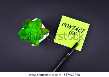 Green sticky note with pen with text CONTACT US