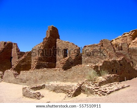 Ancient ruins against brilliant blue sky in Chaco Canyon; at Chaco Culture Historical Park in New Mexico.