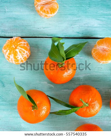 tangerines with green leaves on turquoise wooden background