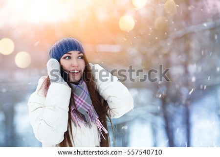 Portrait of smiling young woman talking mobile phone in winter park