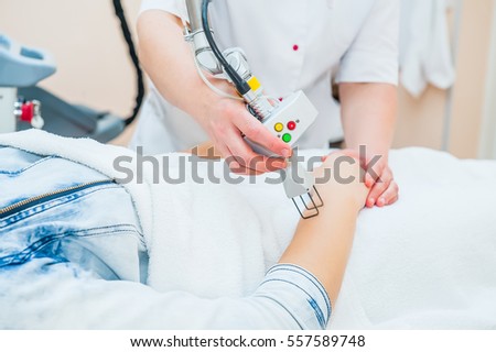 The process of aesthetic laser correction procedure of scars and stretchs on the body in the medical clinic, beauty salon. Close up, selective focus. Royalty-Free Stock Photo #557589748