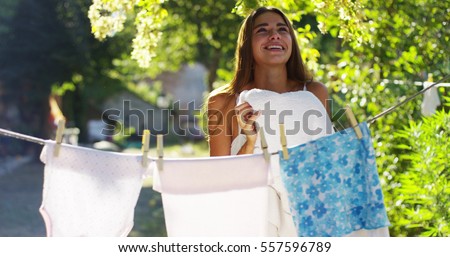 Young woman hangs laundry of her kids. clothes are scented and clean. concept of sustainability, nature and purity, deep clean after washing. Housework
