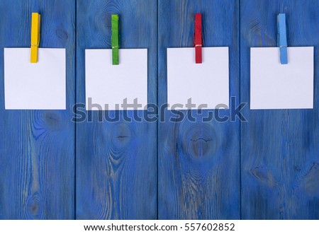 Clothespin hanging with blank photo papers on wooden background texture