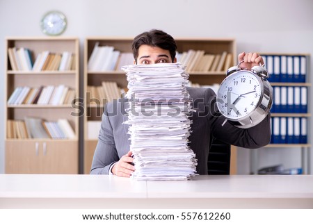 Businessman struggling to meet challenging deadlines Royalty-Free Stock Photo #557612260