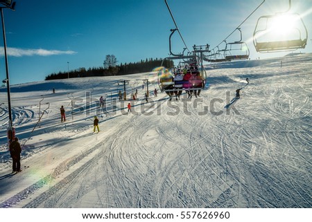 Skiers on the lift - winter ski season in Tylicz resort Royalty-Free Stock Photo #557626960