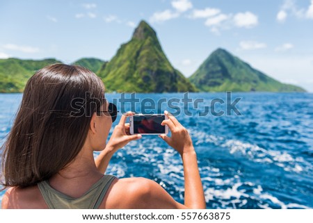 Cruise boat tourist taking mobile phone pictures of Deux pitons peaks, St-Lucia, Caribbean. The Gros and Petit Piton, world heritage site. Woman on shore excursion from ship in Castries, port of call.