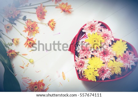 silk red heart box flowers with shadow of wooden battens on white wooden table background on Valentine's Day times with copy space.