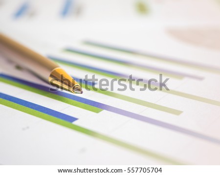 Close pen on business charts and  graph with light effect (Selective focus)