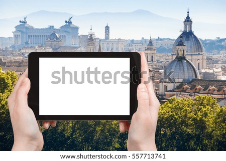 travel concept - tourist photographs buildings in historic center of Rome city on tablet with cut out screen with blank place for advertising in Italy