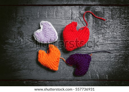 Valentine's Day. Colorful knitted hearts. Red heart on the dark boards. Valentines day. Heart pendant. Red heart. Valentine cards. Space for text. Toning dark colors.