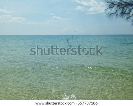 wallpaper of green blue sea view sharing the same border with clear blue sky with sparse clouds 