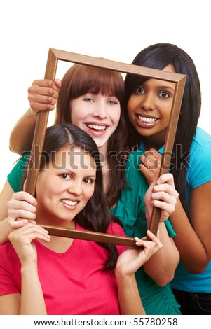 Three young beautiful women looking through an empty frame