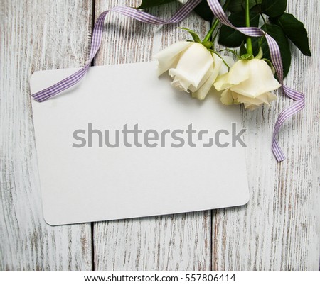 White roses with greeting cardon a old white wooden table