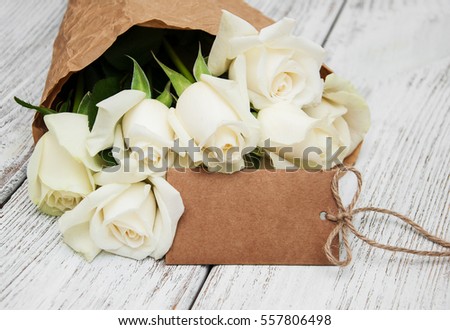White roses with tag on a old white wooden table