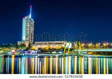 View of the UNO city complex including VIC,UN headquarters and a riverside promenade full of bars and restaurants during night in Vienna, Austria.