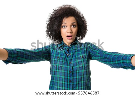 Young beautiful African American woman makes self against the white background in studio