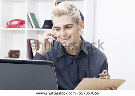 male young speaking by phone phone in the office or in the home