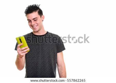 Studio shot of happy young man smiling while using mobile phone isolated against white background