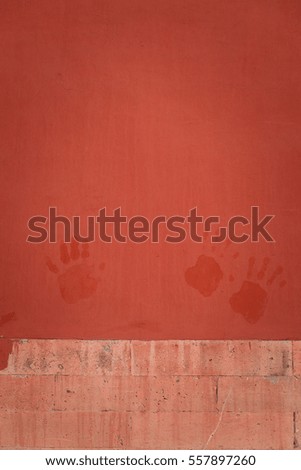 Red paint wall with hand-prints