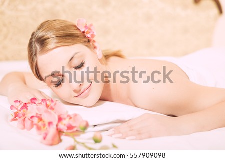 Attractive woman laying on massage spa bed white background, Closeup portrait