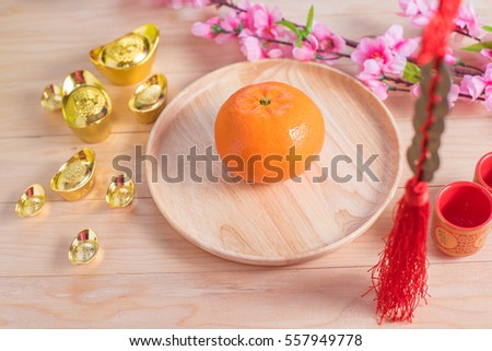 Top view accessories Chinese new year festival decorations.orange,leaf,wood dish,red packet,plum blossom, on wood background