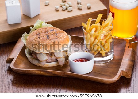 Fastfood burger with potato chips and beer.