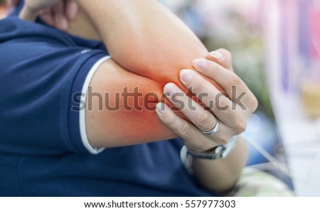 Businessman suffering from elbow pain at office