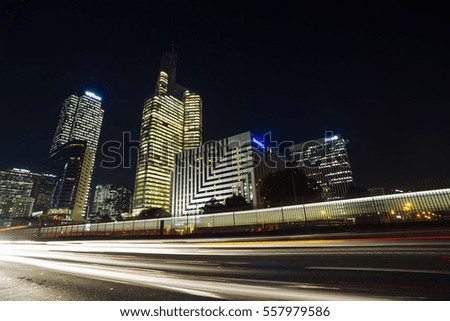 Night architecture - skyscrapers with glass facade. Modern buildings in Paris business district. Evening dynamic traffic on a street. Concept of economics, financial.  Copy space for text. Toned