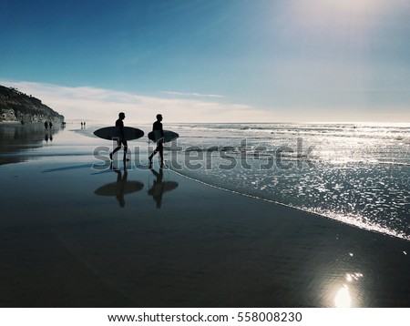 Two surfers on the beach in San Diego Royalty-Free Stock Photo #558008230