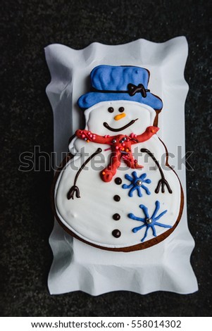 Christmas background with gingerbread in the form a snowman on the white plate. Top view
