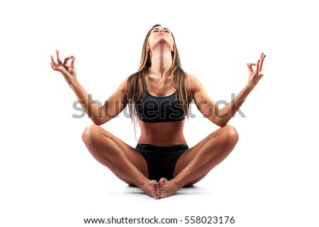 A beautiful young woman practicing Yoga in shorts in a Studio