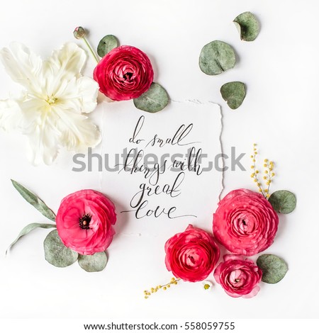 Quote "Do small things with great love" written in calligraphic style on paper with pink, red roses, ranunculus, white tulips and green leaves on white background. Flat lay, top view
