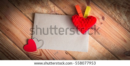 Paper for your text and small red hearts on old wood background. Valentine gift.