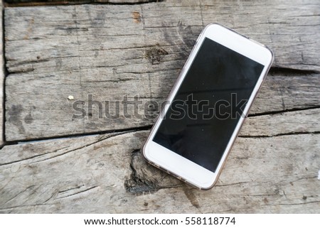White smart phone on wooden table with copy space for text.