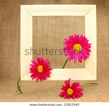 Still life with picture frame and flowers on burlap background