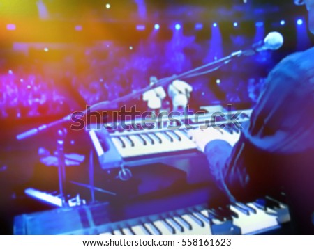 abstract blurred image. Actor playing on the keyboard synthesizer piano keys. Musician plays a musical instrument on the concert stage.                               