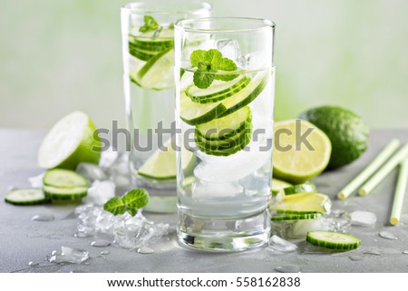 Cold and refreshing infused detox water with lime and cucumber in a glass