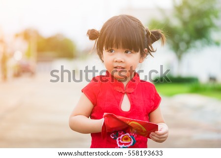 Close up Happy Little asian girl in chinese traditional dress laughing and smiling.Happy Concept.Chinese little girl happy face.happy chinese new year. smiling asian little girl holding red envelope