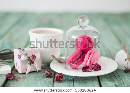 French macaroons cookies gift box and cappuccino cup on a wooden background. Mothers day or Valentines day greeting card