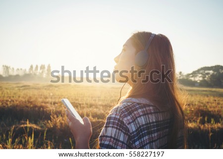 young hipster  beautiful girl listening to music, mobile phone, headphones, enjoying on time