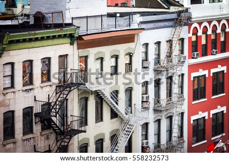 New York City view of historic buildings with windows, rooftops and fire escapes along Bowery street in the Chinatown neighborhood of Manhattan, NYC