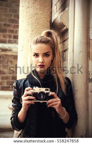 Young beautiful woman holding retro camera