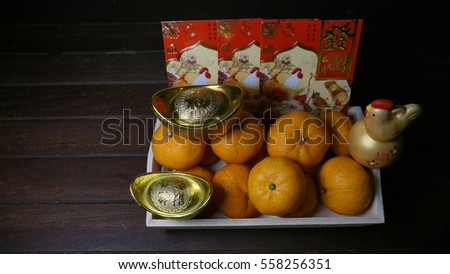 Chinese gold ingots on a rustic wooden background. Chinese text means lucky, wealth and prosperity. Chinese New Year concept.