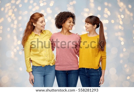 diversity, race, ethnicity, friendship and people concept - international group of happy smiling women hugging over holidays lights background