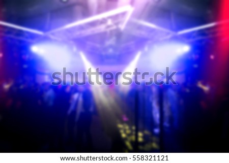 Lights in the club at midnight. Crowd of people at party. Motion blurred picture.